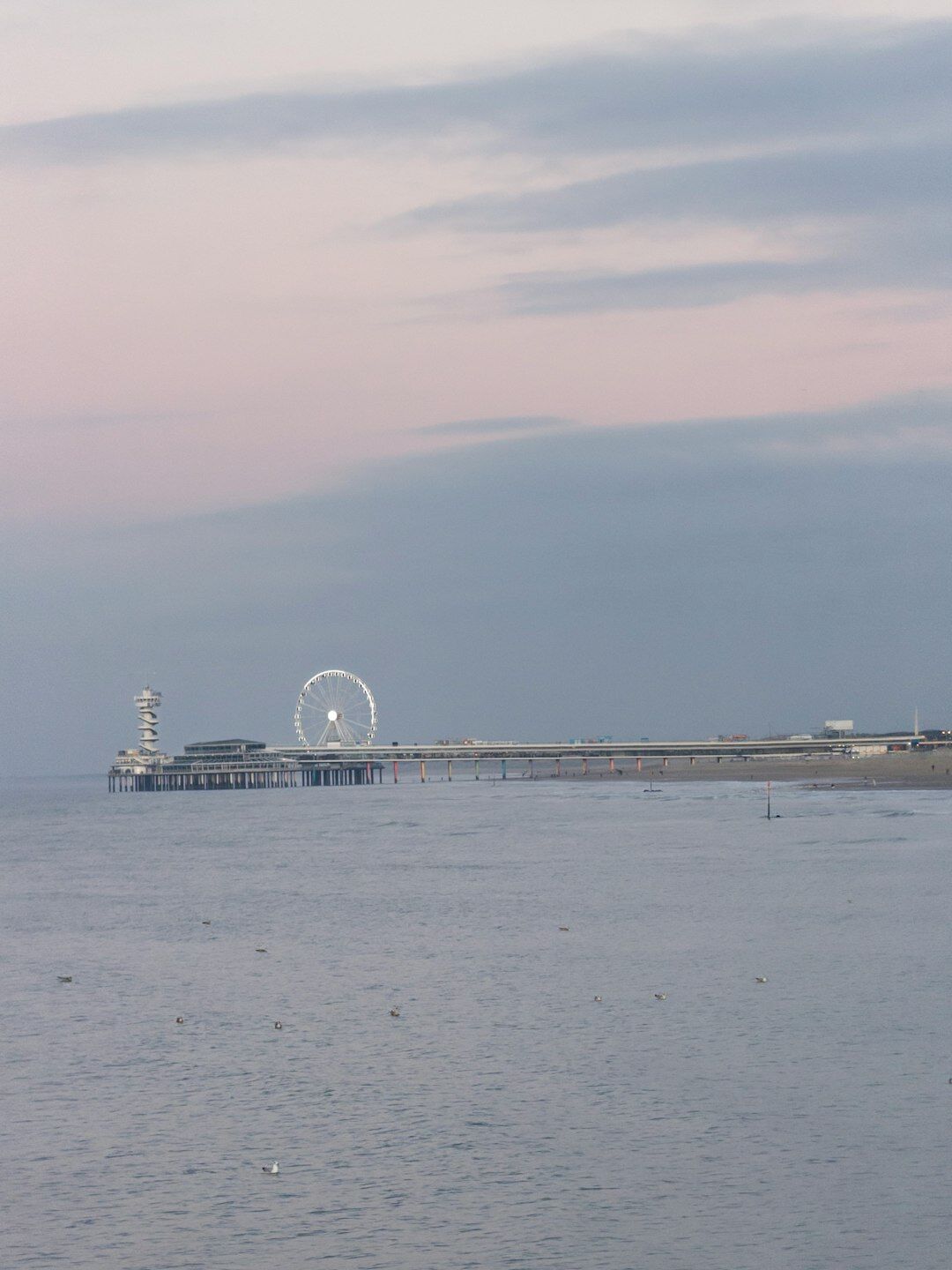 Coastal city promenade at sunset with calm water