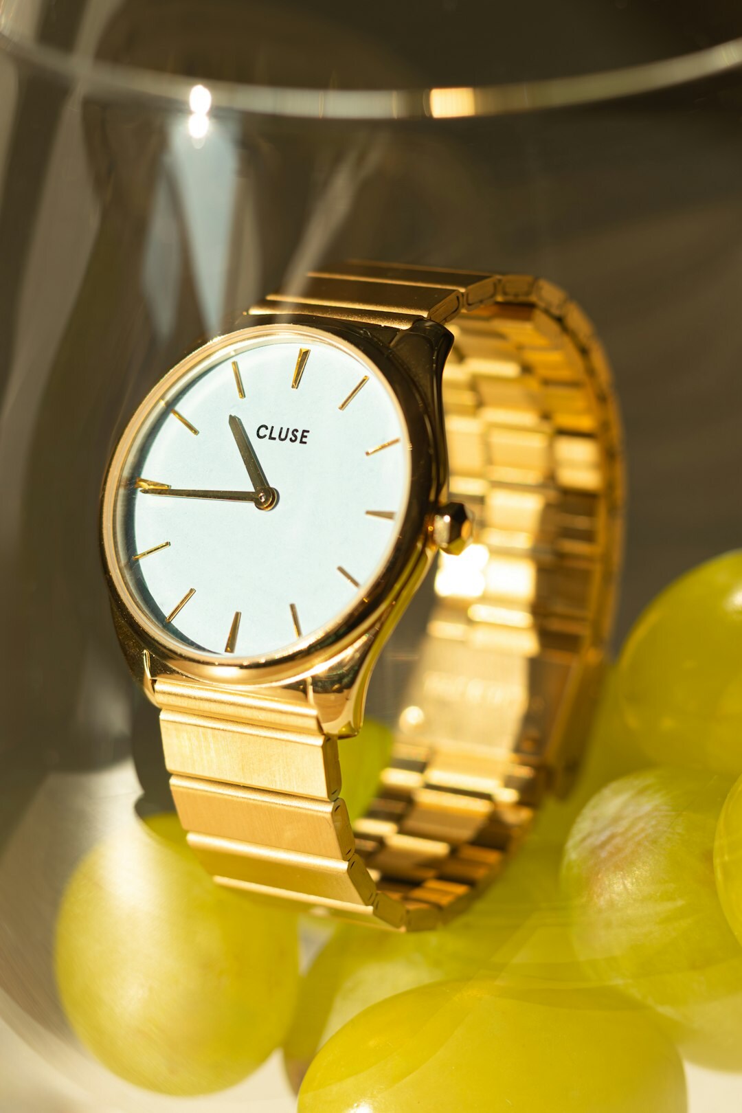 Elegant gold dress watch with dark leather strap on a wooden surface